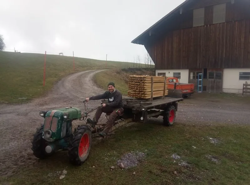 Noch lebt das Paar nicht auf der Alp. Aber am letzten Wochenende hat Manuel Schuler bei nebligem Wetter bereits neue Zäune aufgestellt. Ein Mann auf einem Landwirtschaftsfahrzeug.